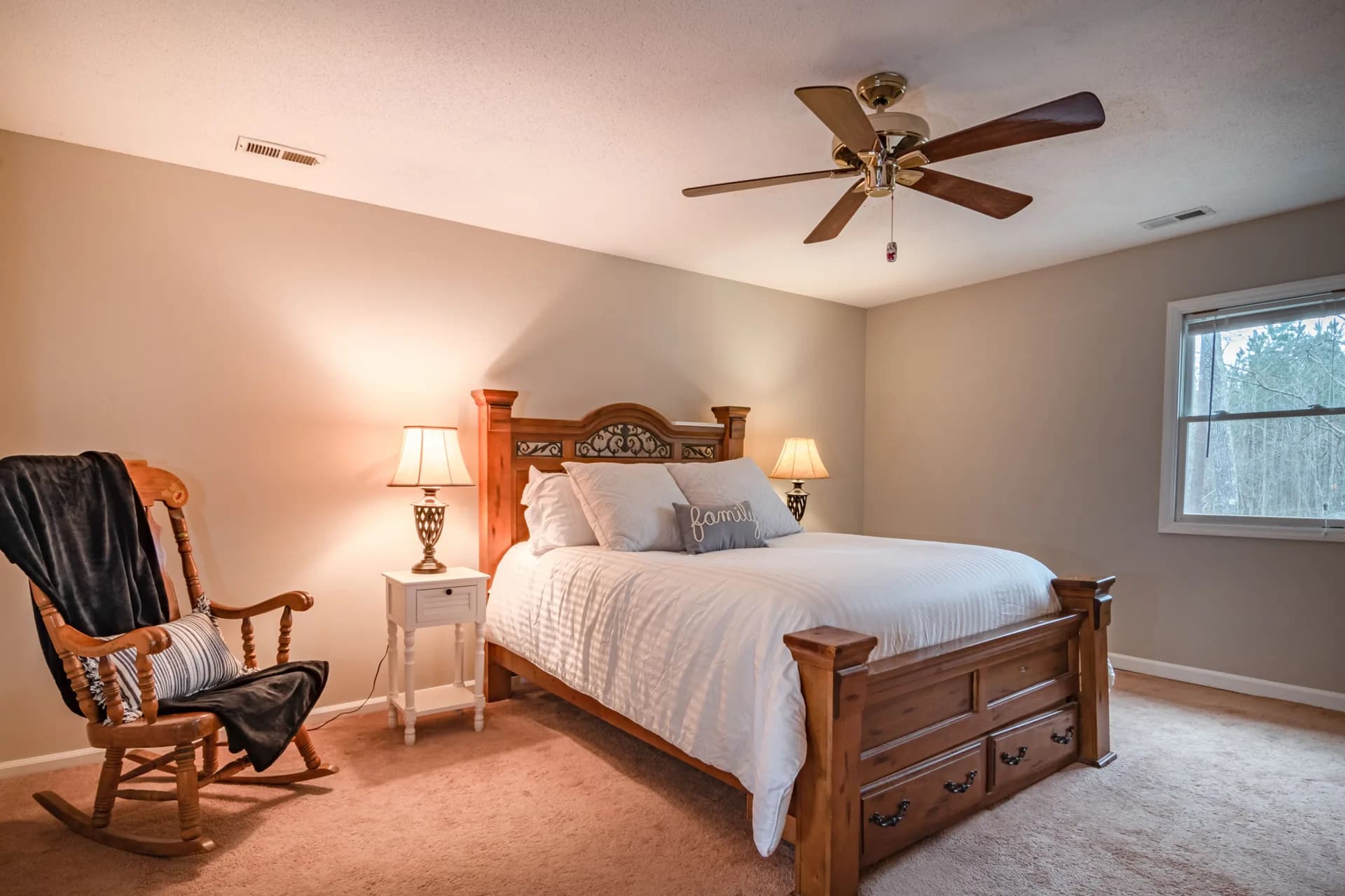 Imagen de ejemplo de BookNoFees: Habitación con una cama grande de madera y una mecedora