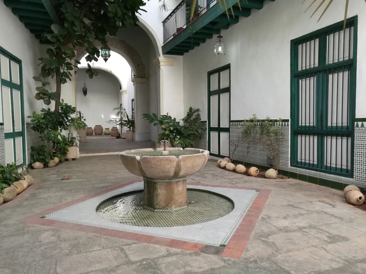 Imagen de ejemplo de BookNoFees: Patio cubano con fuente y puertas pintadas de verde