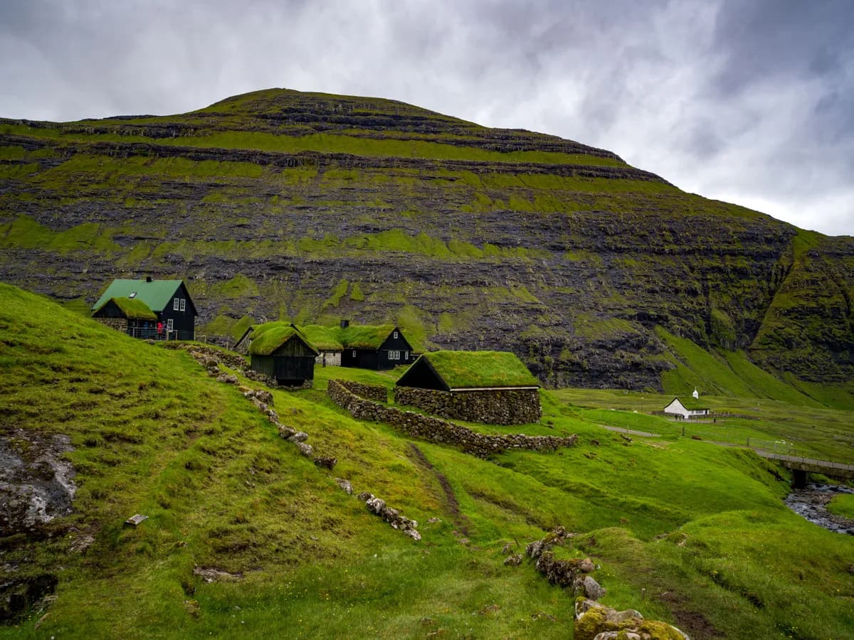 Imagen de ejemplo de BookNoFees: Casas con techos cubiertos de pasto en un paisaje de las Islas Feroe
