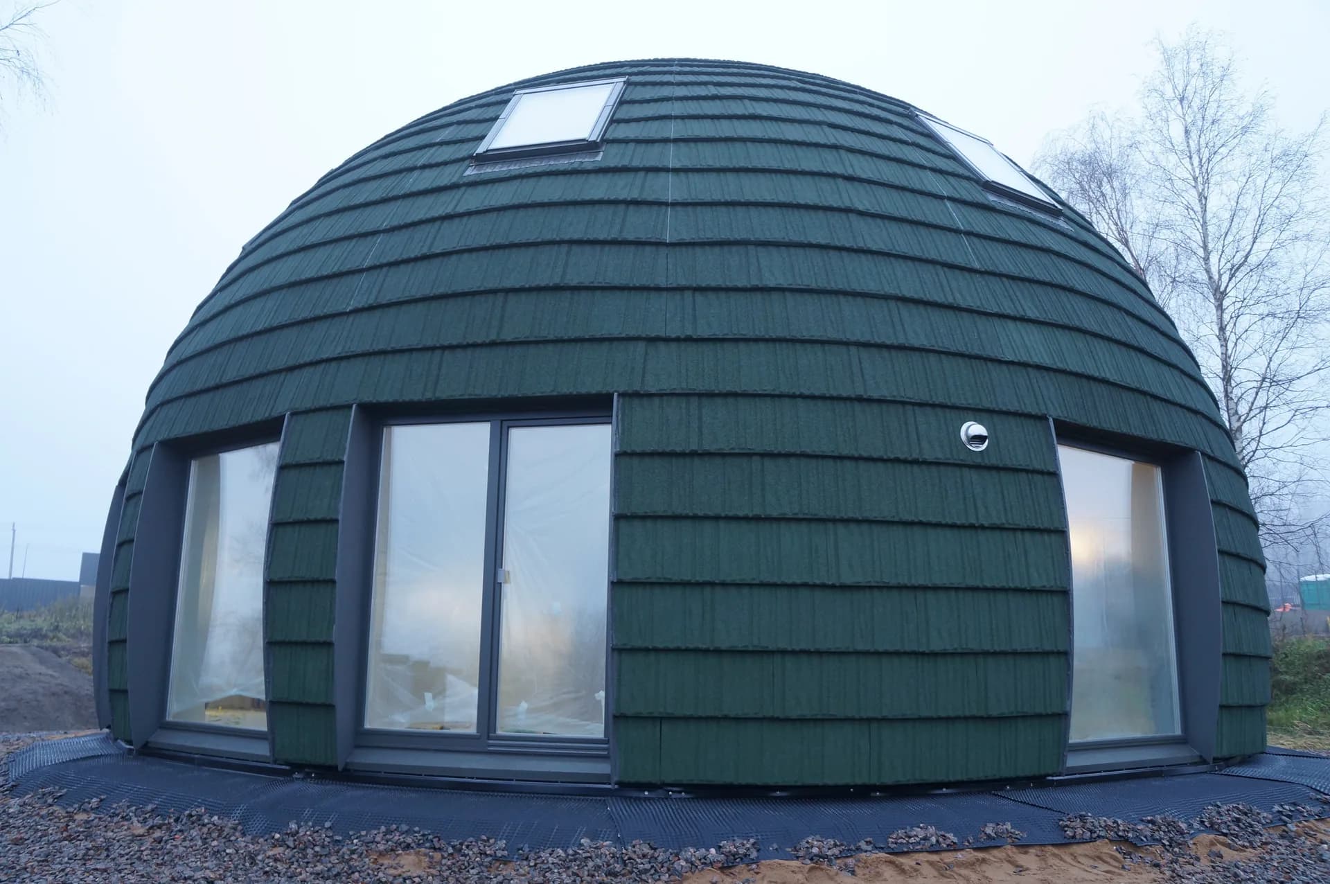 Imagen de ejemplo de BookNoFees: Casa verde con cúpula, grandes ventanas y puerta de entrada triangular