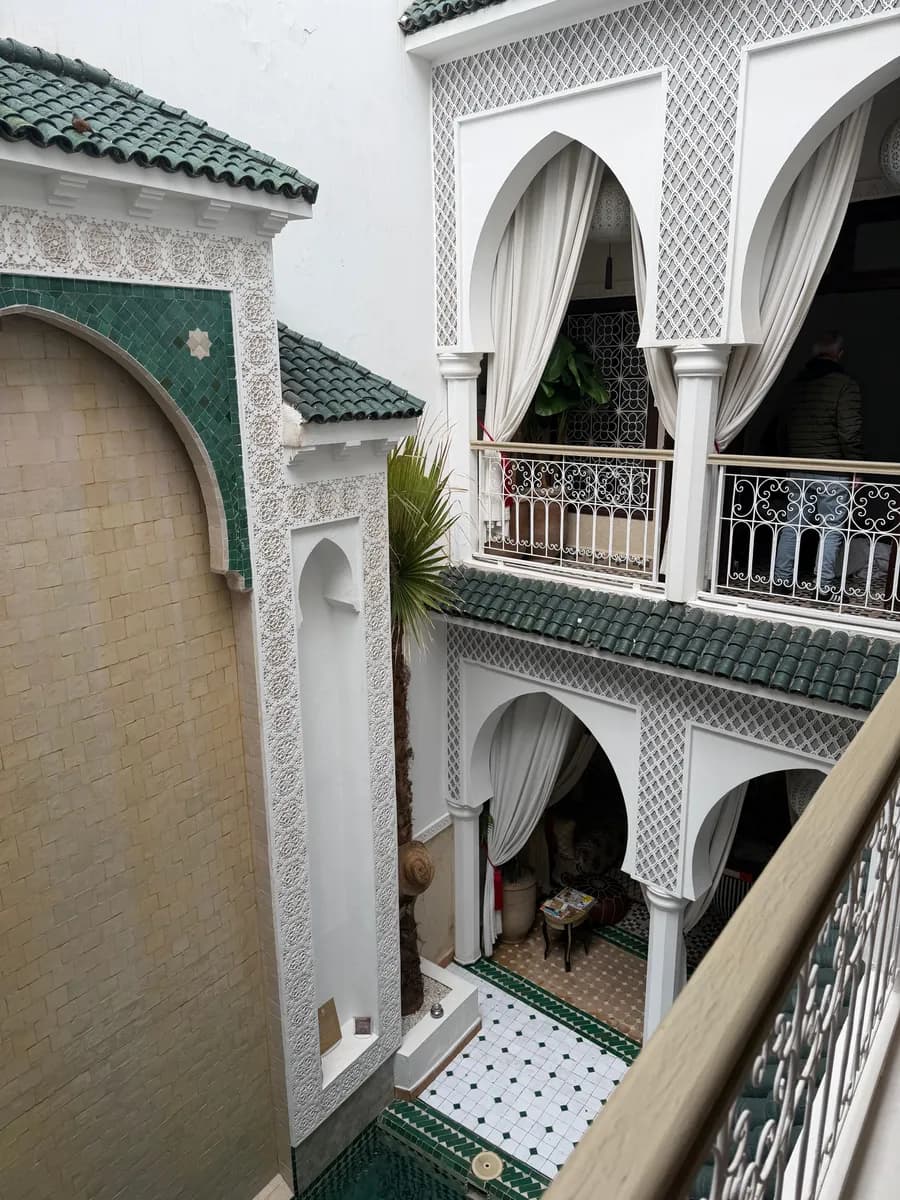 Imagen de ejemplo de BookNoFees: interior de un riad con azulejos estampados y arcos