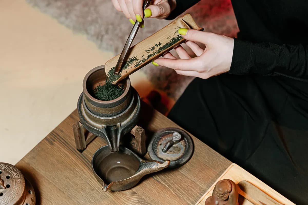 Imagen de ejemplo de BookNoFees: Manos preparando té con una cuchara de bambú