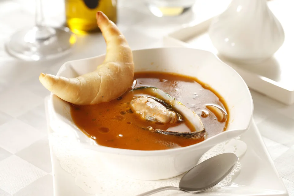 BookNoFees: Foto de ejemplo: Sopa de mariscos servida con pan