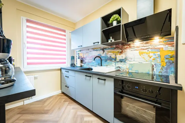 BookNoFees: renta vacacional en Barby, Alemania – Cocina con panel protector pintado, horno negro y persiana rosa
