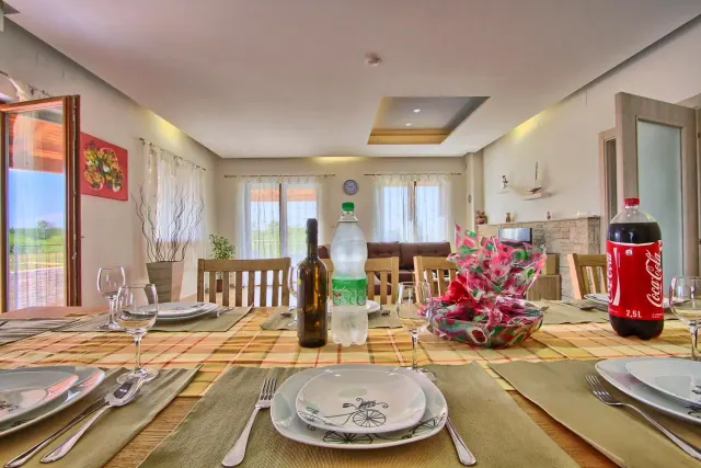 BookNoFees: renta vacacional en Štokovci, Croacia – una mesa de comedor con platos y botellas de vino sobre ella en Villa Stokovci, en Štokovci