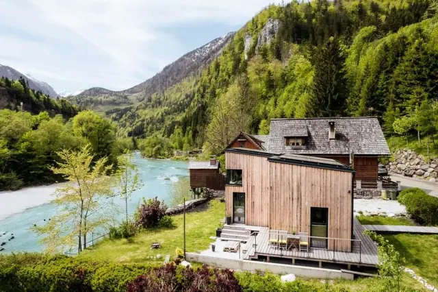 BookNoFees: renta vacacional en Hieflau – Vista exterior de una casa de vacaciones de madera con el río y las montañas como telón de fondo