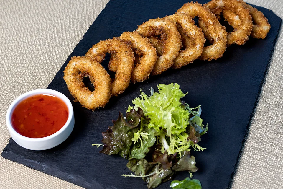 Foto de ejemplo: Aros de calamares fritos con ensalada y salsa para mojar