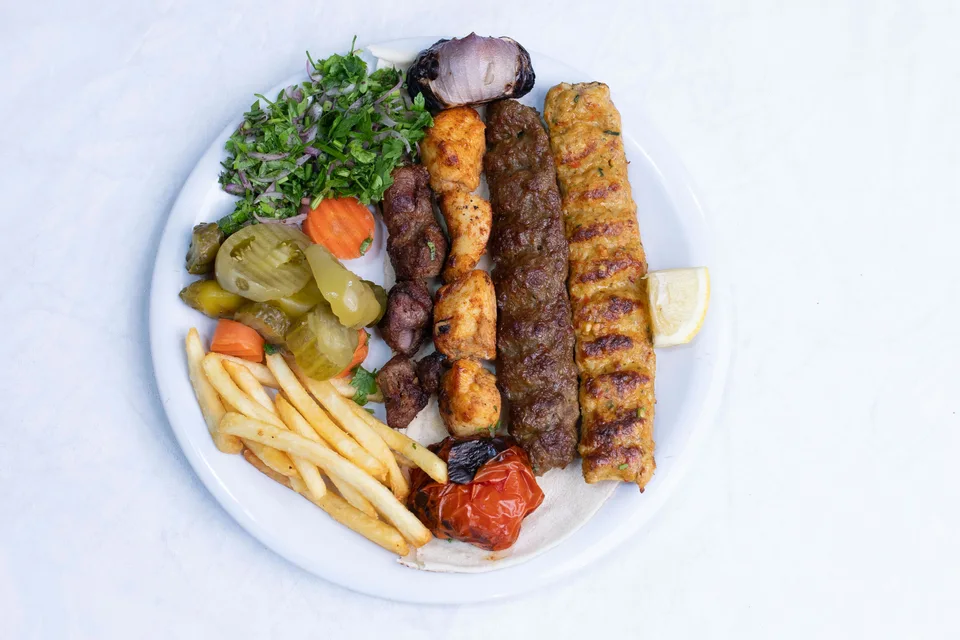 BookNoFees: Foto de ejemplo: Brochetas a la parrilla servidas con ensalada y papas fritas