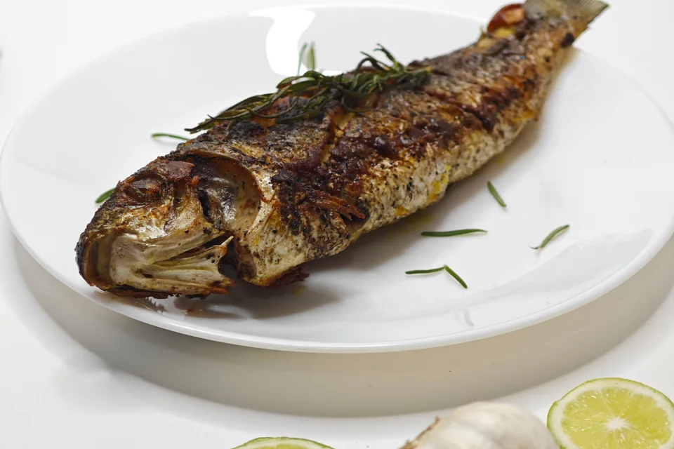 Foto de ejemplo: Pescado entero a la parrilla en un plato blanco